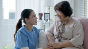 A senior resident sitting in a cozy living room with a small dog resting beside them on a couch.