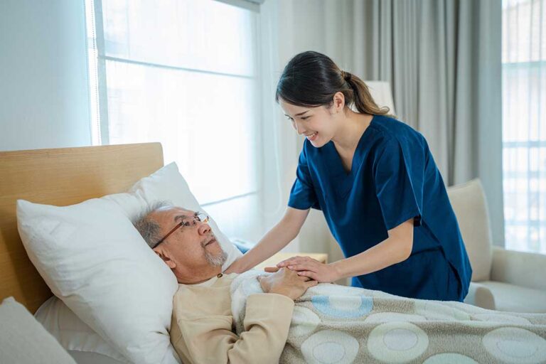 Adult child talking with elderly parent while unpacking personal items in a bright assisted living room.